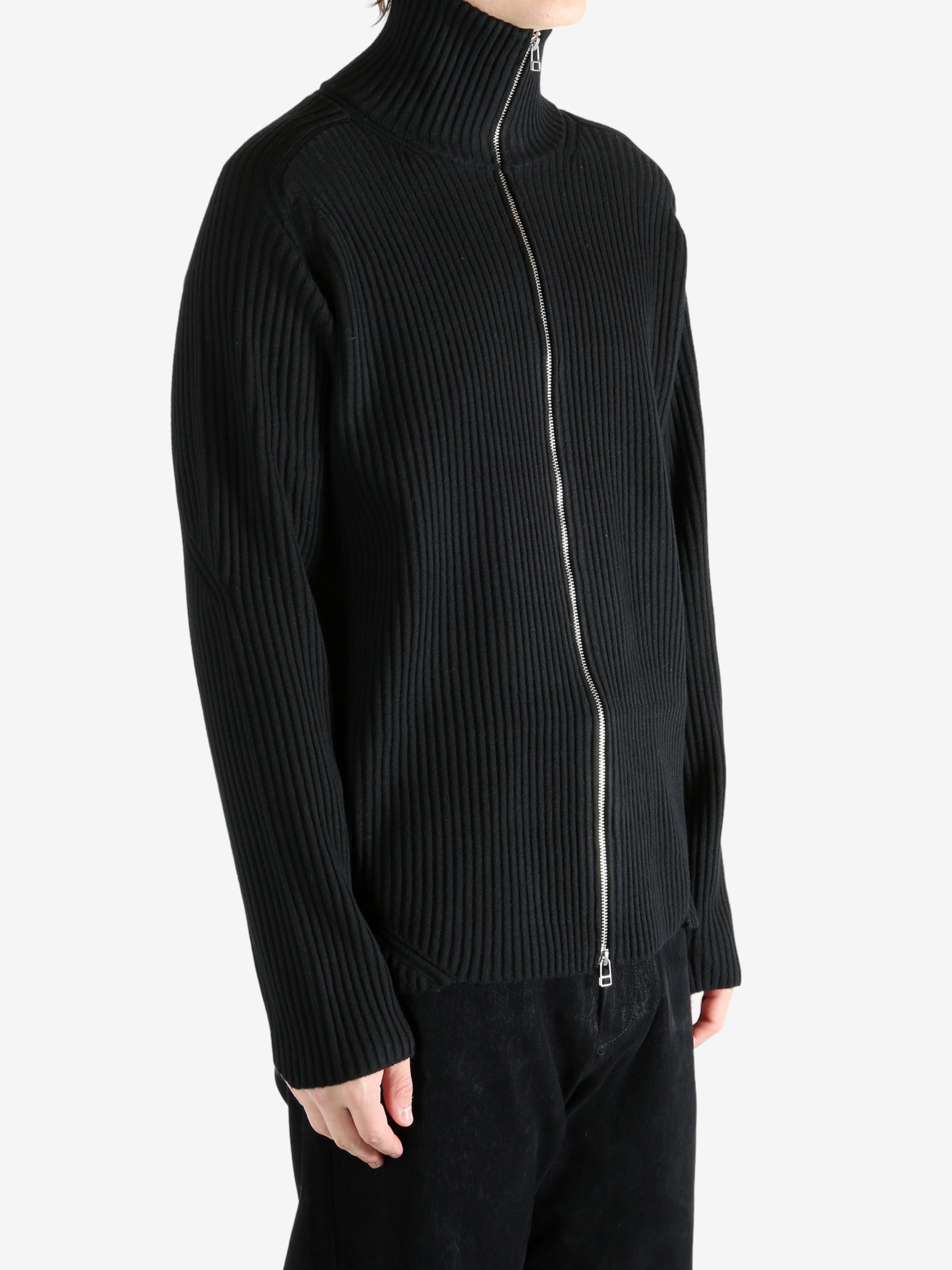 Black knitwear worn by a person, showing the knitwear's fit