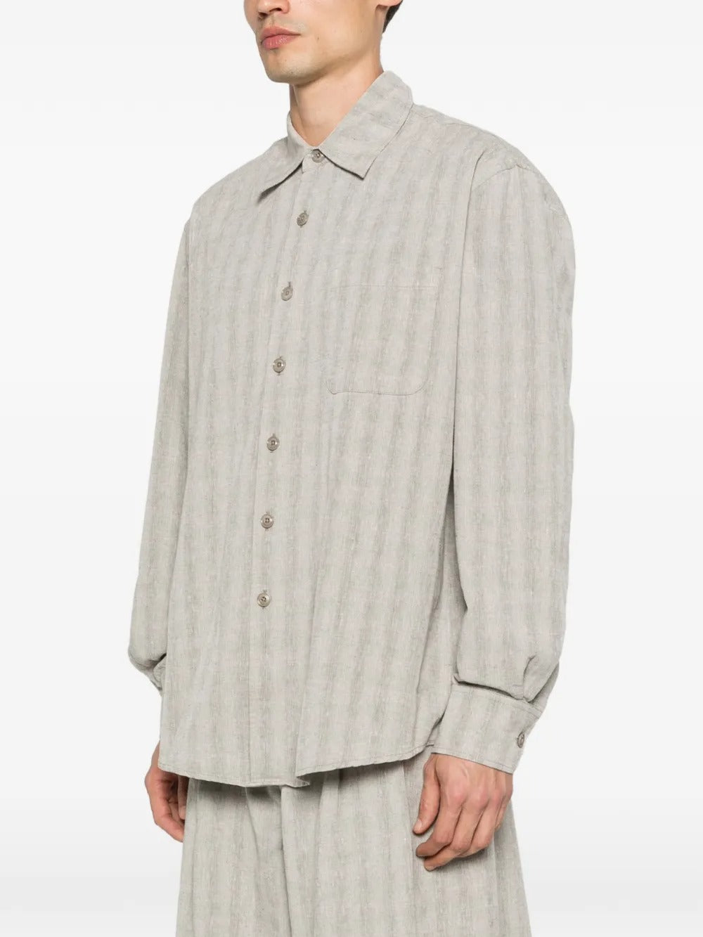 Grey shirts worn by a person, showing the shirts' fit