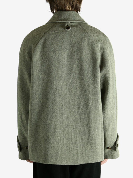 Green jacket worn by a person, showing the jacket fit