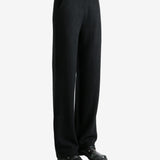 Black pants worn by a person, showing the pants' fit