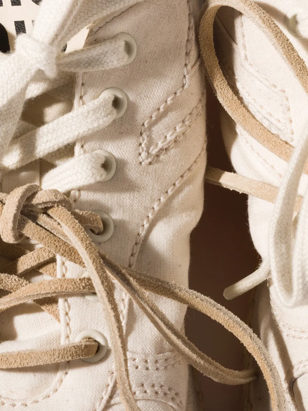 Close up of white sneaker, showing texture of the canvas fabric