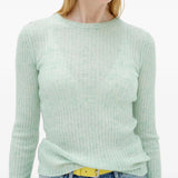 Green knitwear worn by a person, showing the knitwear fit
