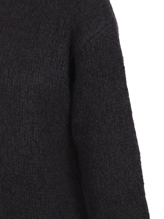 Close up of the navy knitwear, showing texture of the cashmere and wool fabric