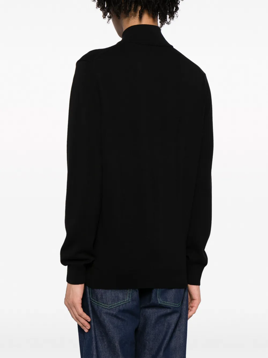 Black sweater worn by a person, showing the sweater fit