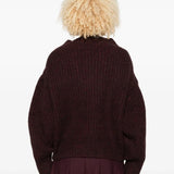 Red sweater worn by a person, showing the sweater's fit