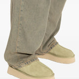 Green shoes worn by a person, showing the shoes' fit