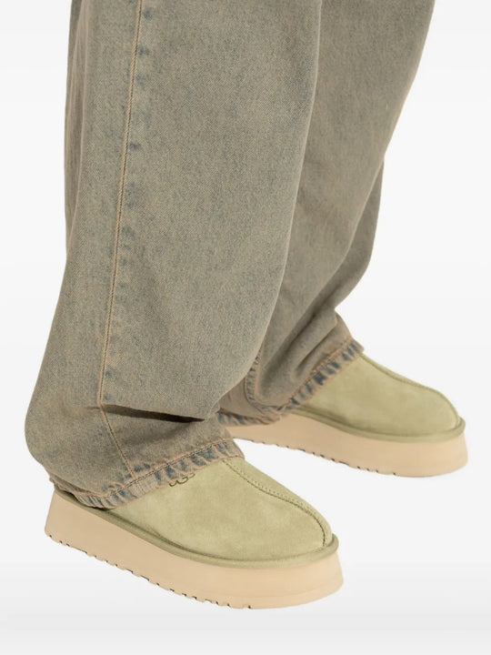 Green shoes worn by a person, showing the shoes' fit