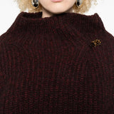 Close up of the red sweater, showing texture of the wool fabric