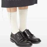 Black shoes worn by a person, showing the shoes' fit