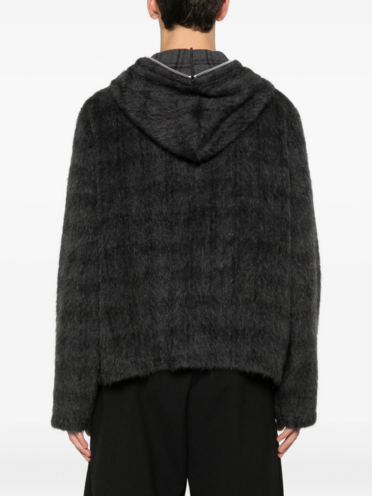 black hoodie worn by a person, showing the hoodie fit