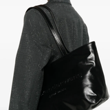 Black handbag worn by a person, showing the handbag fit