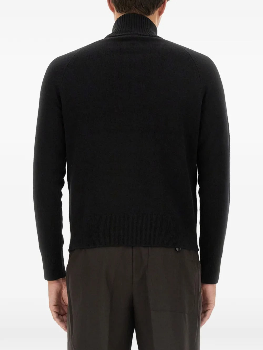 Black knitwear worn by a person, showing the knitwear's fit