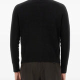 Black knitwear worn by a person, showing the knitwear's fit