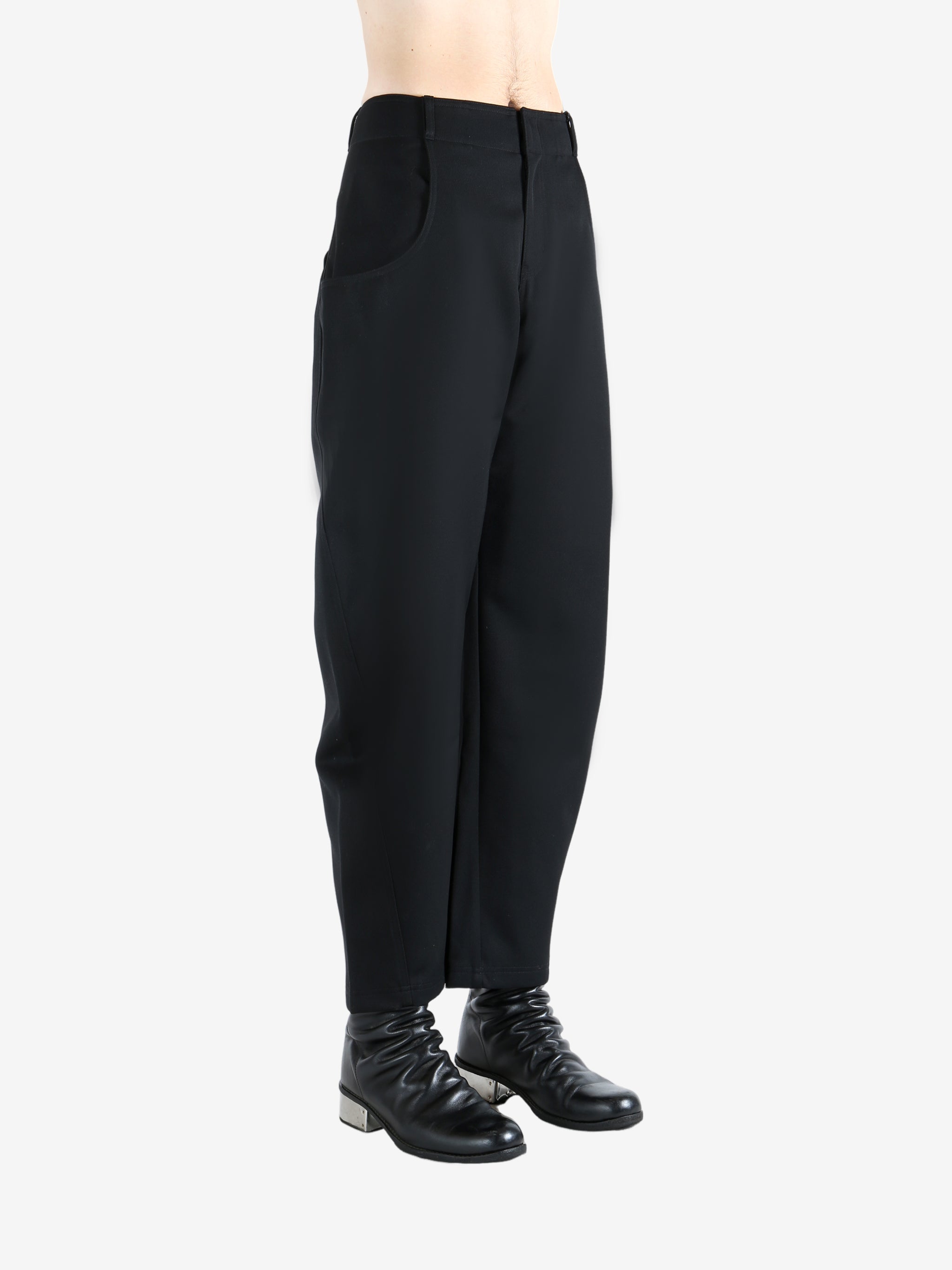 Black pants worn by a person, showing the pants' fit