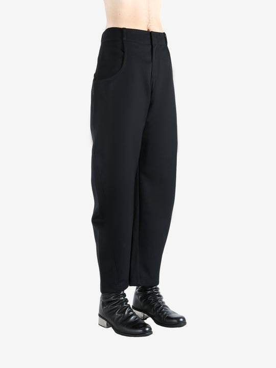 Black pants worn by a person, showing the pants' fit