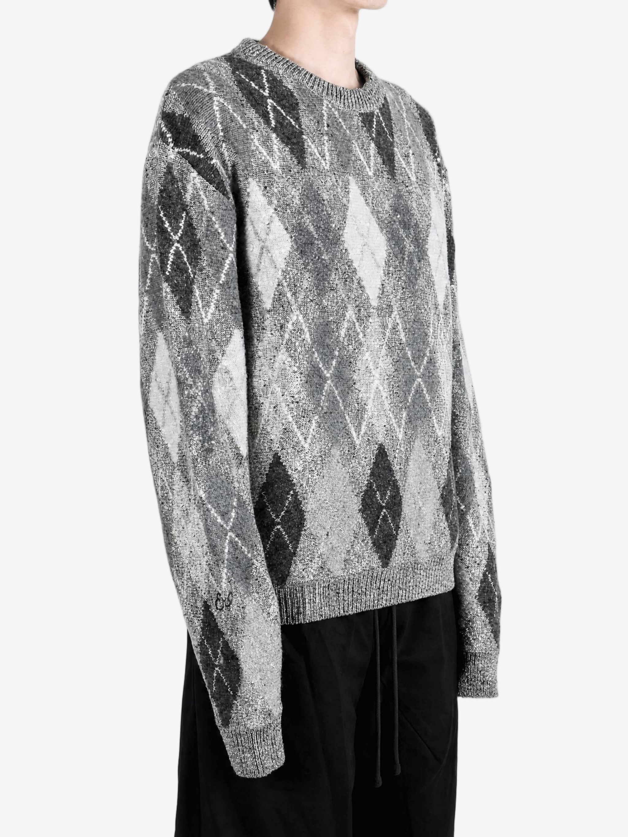 Grey knitwear worn by a person, showing the knitwear fit