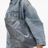 Gray tote bag worn by a person, showing the bag fit