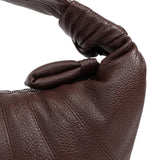 Close up of the brown bag, showing texture of the leather fabric