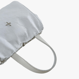 Close-up of white bag, showing texture of the fabric