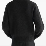 Black knitwear worn by a person, showing the knitwear fit