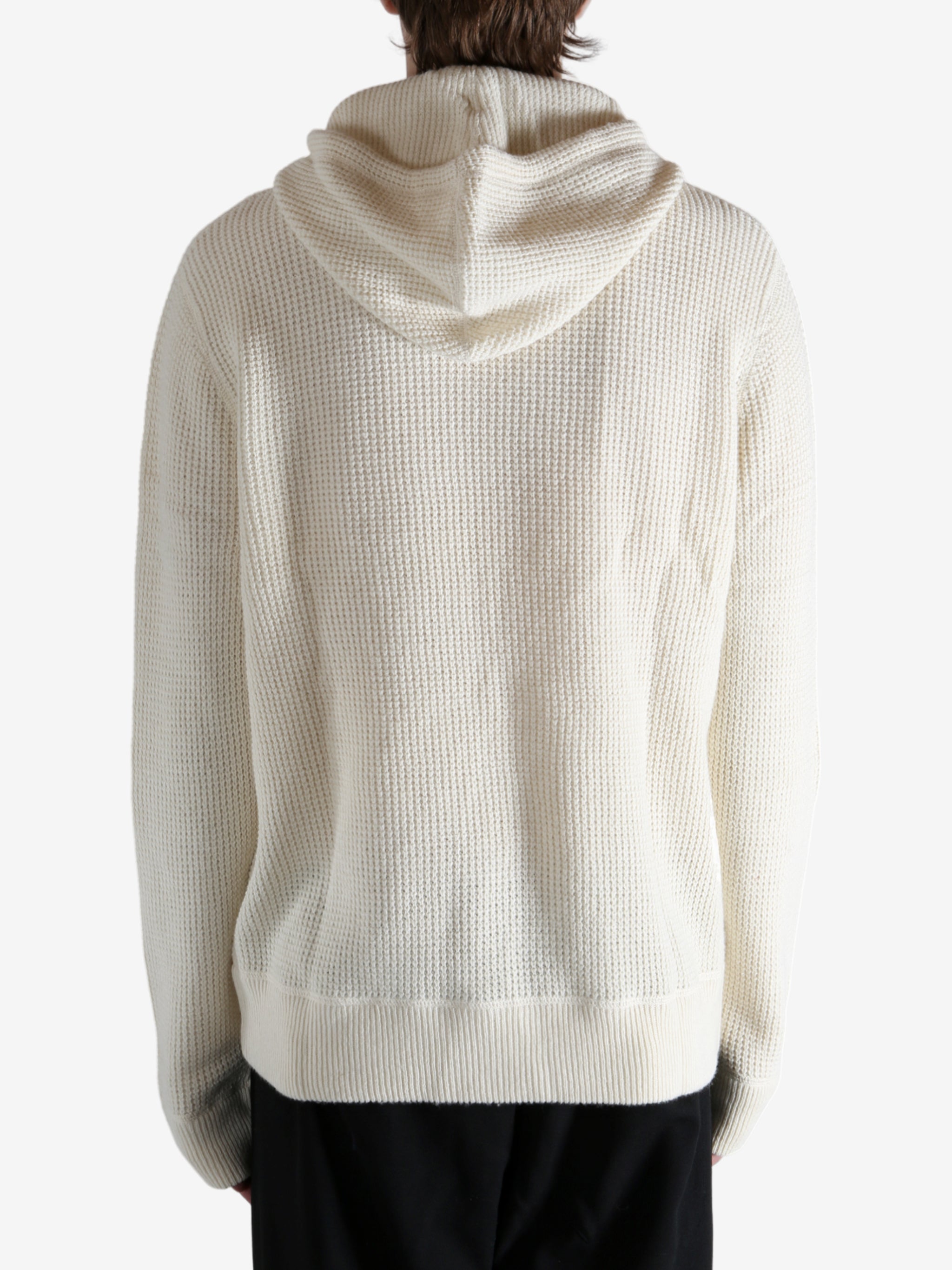 White knitwear worn by a person, showing the knitwear's fit
