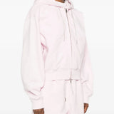 Pink hoodie worn by a person, showing the hoodie's fit
