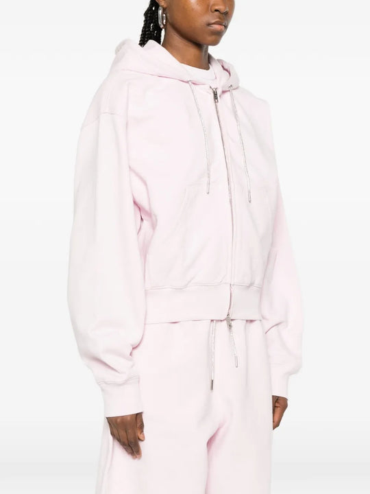 Pink hoodie worn by a person, showing the hoodie's fit