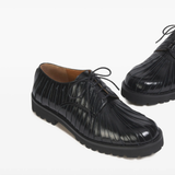 Close up of black shoes, showing texture of the Calf Leather fabric