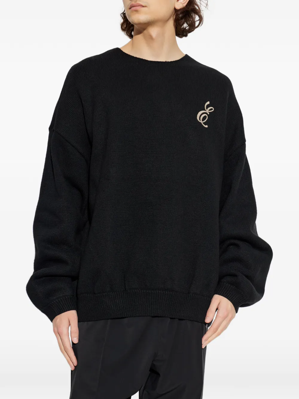 black sweater worn by a person, showing the sweater fit