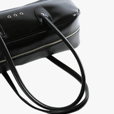 Close up of black handbag,showing texture of the polyethylene fabric.