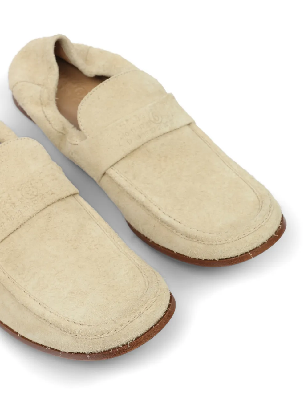 close up of tan loafers-mules, showing texture of the leather fabric