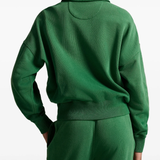 Green sweatshirt worn by a person, showing the sweatshirt‘s fit