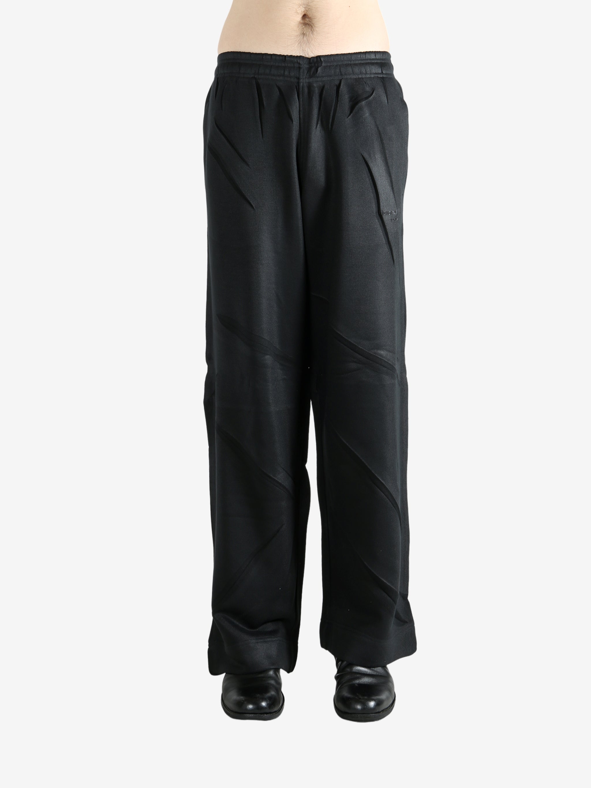 Black pants worn by a person, showing the pants' fit