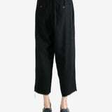 Black pants worn by a person, showing the pants fit