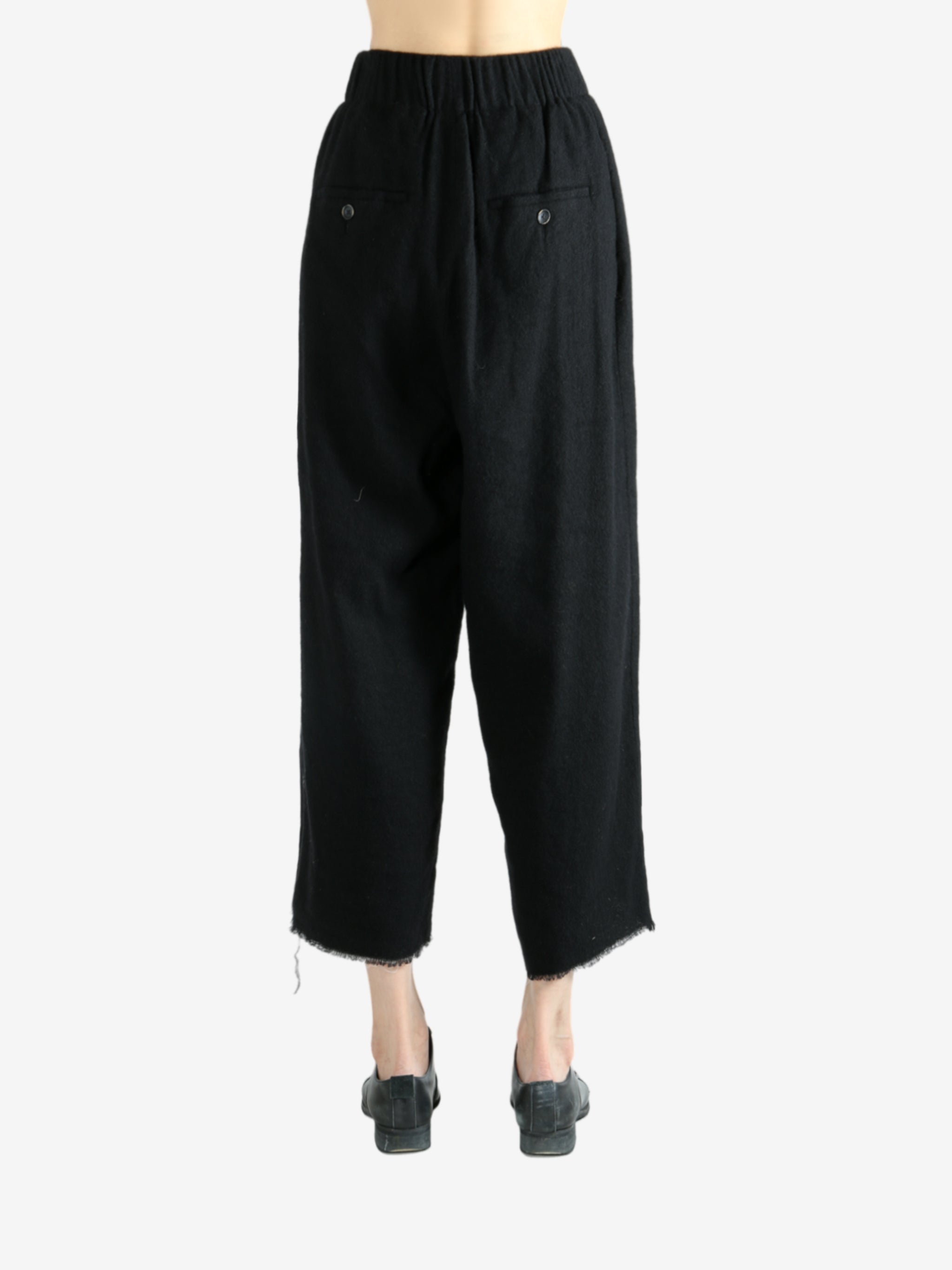 Black pants worn by a person, showing the pants fit