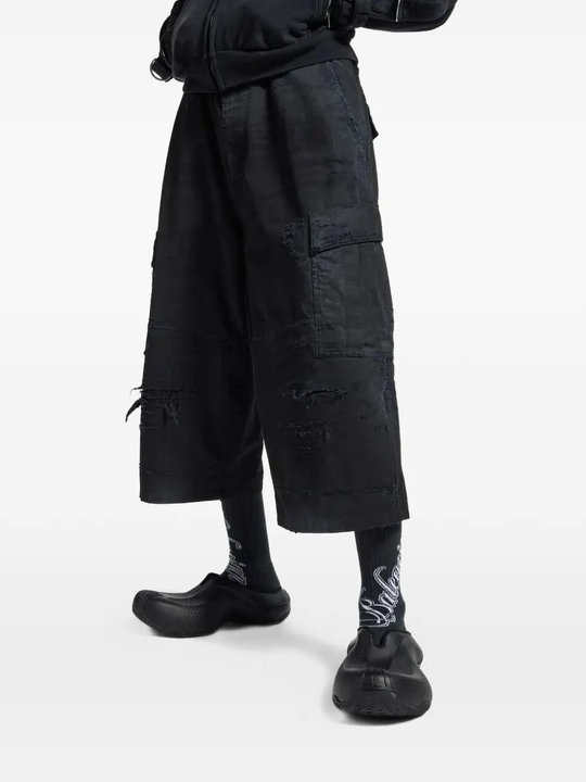 Black pants worn by a person, showing the pants' fit