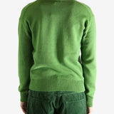 Green knitwear worn by a person, showing the knitwear's fit