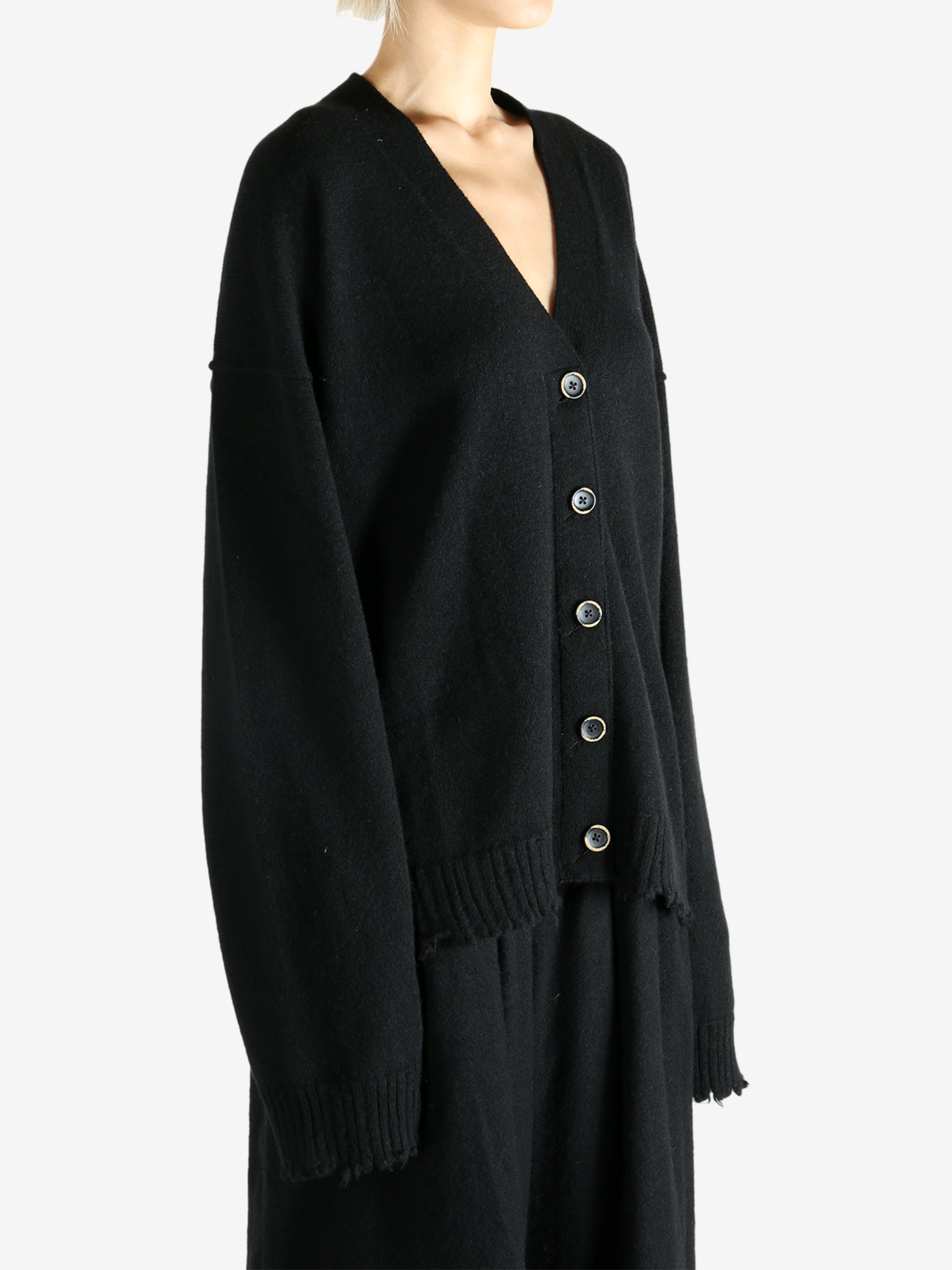 Black knitwear worn by a person, showing the knitwear's fit