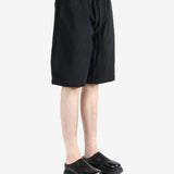 Black short worn by a person, showing the short's fit