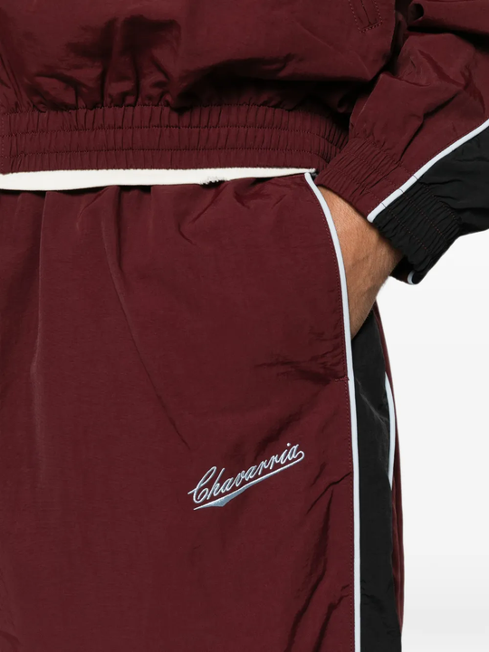 Burgundy pants worn by a person, showing the pants fit