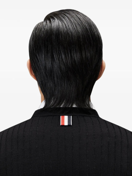 Black knitwear worn by a person, showing the knitwear fit