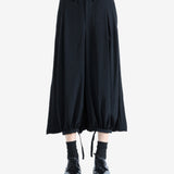 Black pants worn by a person, showing the pants' fit