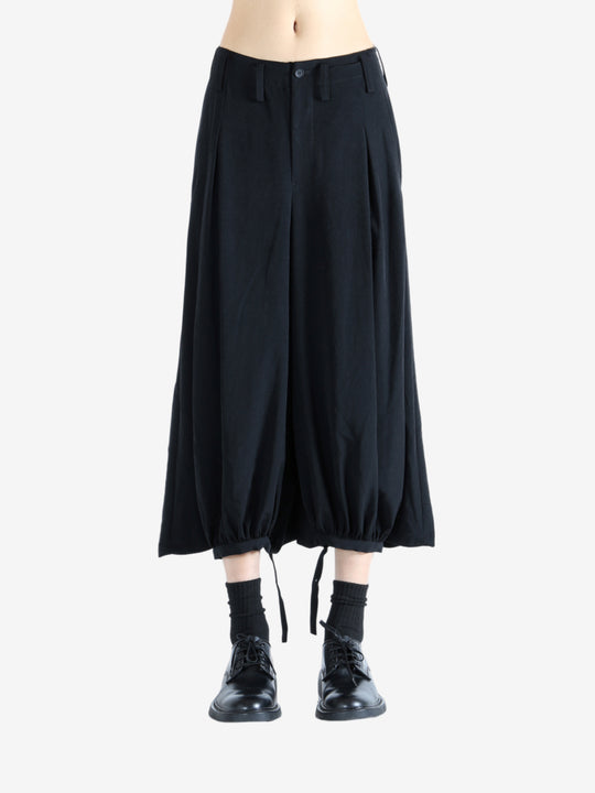 Black pants worn by a person, showing the pants' fit