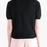 Black knitwear worn by a person, showing the knitwear's fit