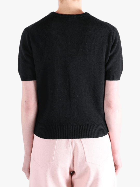 Black knitwear worn by a person, showing the knitwear's fit