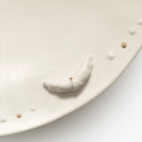 JINJIN PARIS Croissant Shallow Bowl detail with sculpted croissant accent and raised porcelain bead trim.