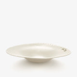 JINJIN PARIS Croissant Shallow Bowl in ivory porcelain, angled view with croissant detail and dotted rim.