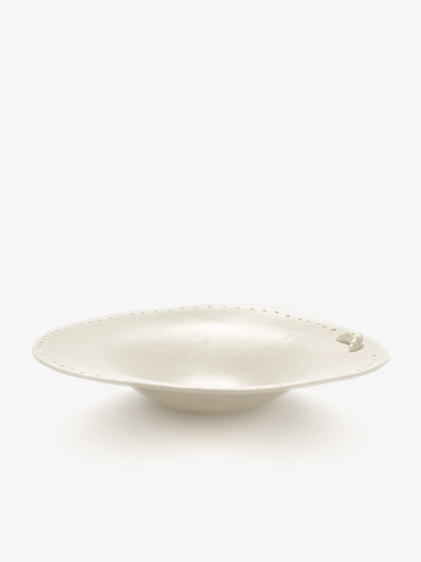 JINJIN PARIS Croissant Shallow Bowl in ivory porcelain, angled view with croissant detail and dotted rim.