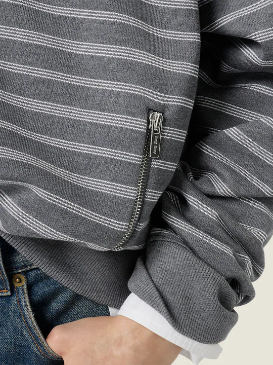 Tan knitwear worn by a person, showing the knitwear fit