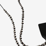 Close up of black necklace, showing texture of the silver fabric